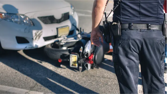image of a motor vehicle partially on top of a knocked over motorcycle